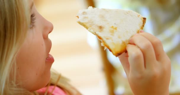 の家のキッチンでピザを抱えている女の子 — ストック動画