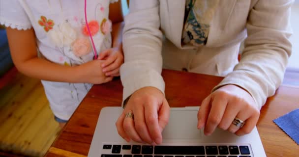 母亲和女儿在家里使用笔记本电脑时相互交流4K — 图库视频影像