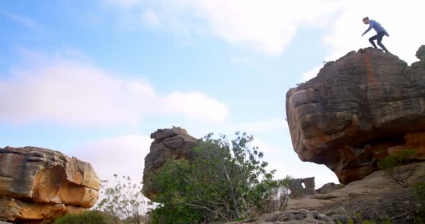 在阳光明媚的日子里 男徒步者站在洛基山的顶端4K — 图库视频影像