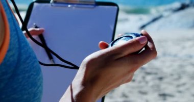 Kronometre ve pano plaj 4 k tutan kadın voleybol antrenörü