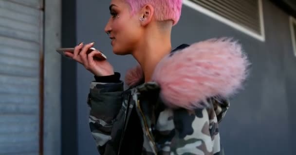 笑顔ショップ の外で携帯電話で話しているピンク髪の女性 — ストック動画