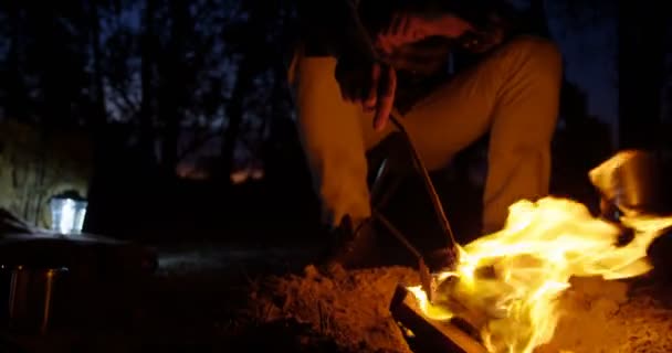Człowiek Siedzi Pobliżu Ognisko Lesie Nocy — Wideo stockowe