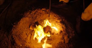 Adam yemek yemek ormanda kamp ateşi üzerinde gece 4 k