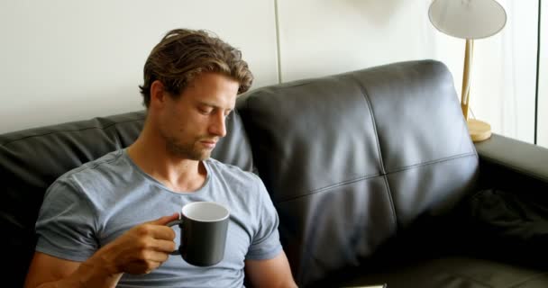 Άνθρωπος Που Έχει Καφέ Διαβάζοντας Ένα Βιβλίο Στο Σαλόνι Στο — Αρχείο Βίντεο