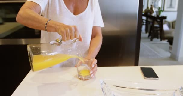 Γυναίκα Προσθετικό Πόδι Πίνοντας Χυμό Πορτοκάλι Στην Κουζίνα Στο Σπίτι — Αρχείο Βίντεο