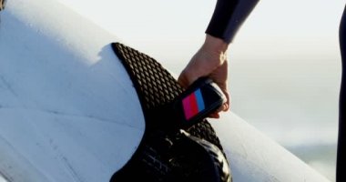 Erkek sörfçü surfboard Beach 4 k ile yürüyüş orta bölümünde