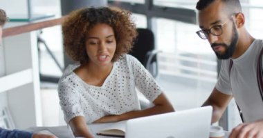 Office 4 k içinde laptop üzerinde tartışırken iş arkadaşları