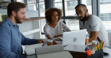 Office 4 k içinde laptop üzerinde tartışırken iş arkadaşları