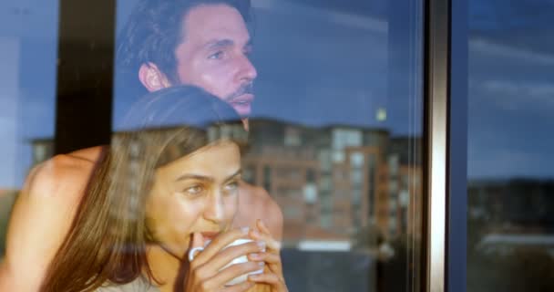 夫妇看通过窗口 而在家里喝咖啡4K — 图库视频影像