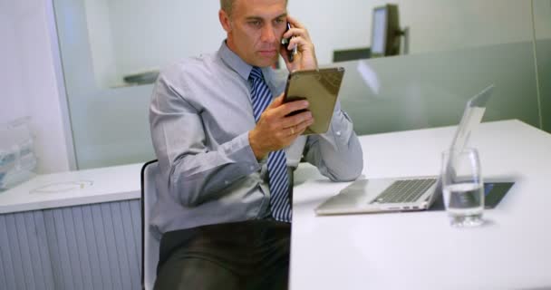 Biznesmen Pomocą Cyfrowego Tabletu Podczas Rozmowy Telefon Komórkowy Biurze — Wideo stockowe