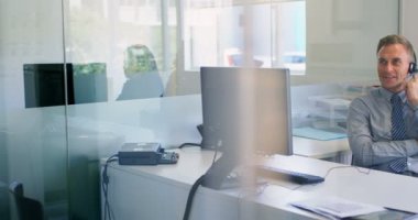 Kulaklık üzerinde Office 4 k bilgisayarda çalışırken konuşmak işadamı