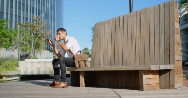 Uomo Seduto Sulla Panchina Parlare Telefono Cellulare Una Giornata Sole — Video Stock
