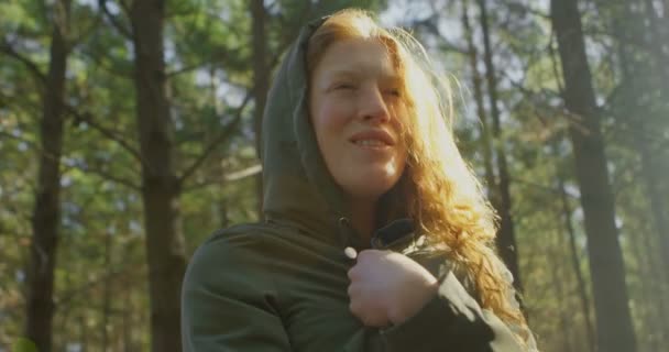 年轻妇女在帽衫站立在森林4K — 图库视频影像