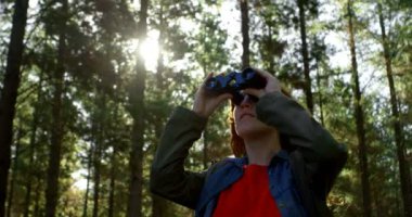 Genç kadın 4 k ormandaki dürbün üzerinden seyir