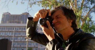 Erkek fotoğrafçı fotoğraf şehirde güneşli bir günde 4 k sokak çekmek
