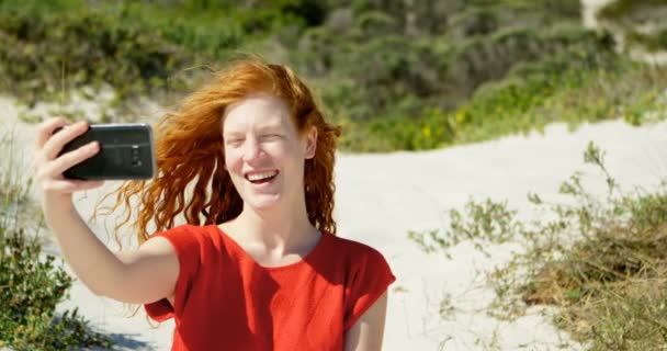 在阳光明媚的日子 在海滩上用手机自拍的女人4K — 图库视频影像