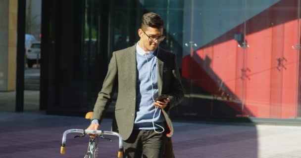 Man Använder Mobiltelefon Medan Promenader Gatan Solig Dag — Stockvideo