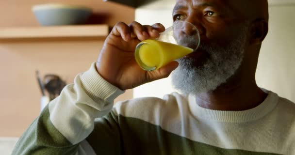 ホームの でキッチンでジュースのガラスを飲む年配の男性 — ストック動画