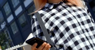 Cep telefonu açık havada 4 k kullanan güzel genç kadın