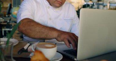 Ticari mutfak 4 k sayacında laptop üzerinde çalışan Şef