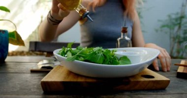 Genç kadın restoranda 4 k salata zeytin yağ boşaltma