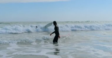 Denizin dalgaları 4 k ortasında duran kadın sörfçü