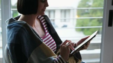 Dijital tablet ev 4 k oturma odasında kullanan kadın