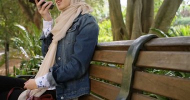 Cep telefonu 4 k bahçesinde konuşurken hijab kadında