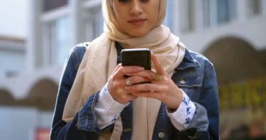 Genç kadın cep telefonuyla şehirde 4 k türban