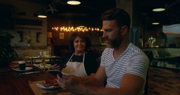 男客户通过手机在面包店4K — 图库视频影像