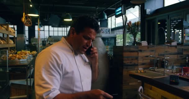 Chef Masculino Hablando Por Teléfono Móvil Panadería — Vídeos de Stock