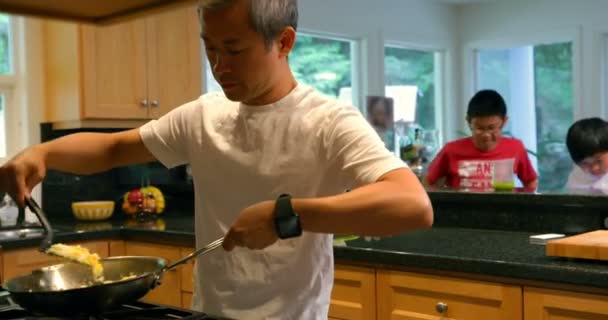 父亲做饭 而他的儿子在家里的背景下玩4K — 图库视频影像