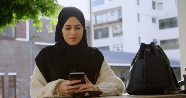 Усміхнена Жінка Хіджабі Використовує Свій Телефон Відкритому Кафе — стокове відео