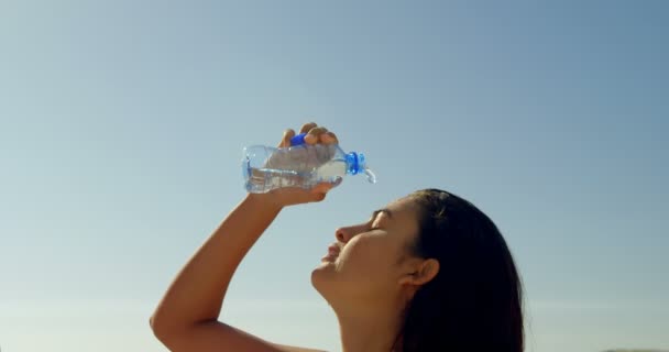 女性サーファーのビーチ に彼女の顔に水を注ぐ — ストック動画
