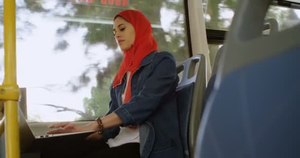 妇女在头巾使用笔记本电脑在公共汽车4K — 图库视频影像