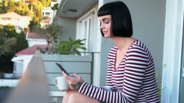 Mulher Tomando Café Enquanto Usa Telefone Celular Varanda Casa — Vídeo de Stock
