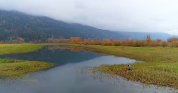 Man Ontspannen Met Zijn Hond Buurt Van Lakeside Platteland — Stockvideo