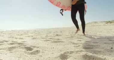 Sörfçü Sahilde güneşli bir günde 4 k çalıştıran surfboard ile 