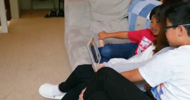 Anne ve oğlu dijital tablet oturma odasında ev 4 k kullanma.
