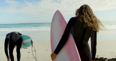 4 k sahilde yürüyüş surfboard ile çiftin arkadan görünüş