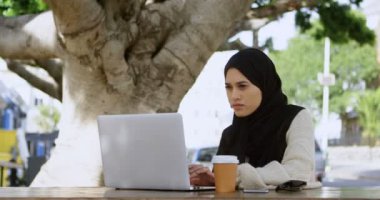 Dizüstü bilgisayar açık kafede 4 k kullanarak hijab özenli kadında