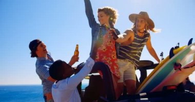 Bira şişeleri 4 k plajda arabada toasting arkadaş grubu