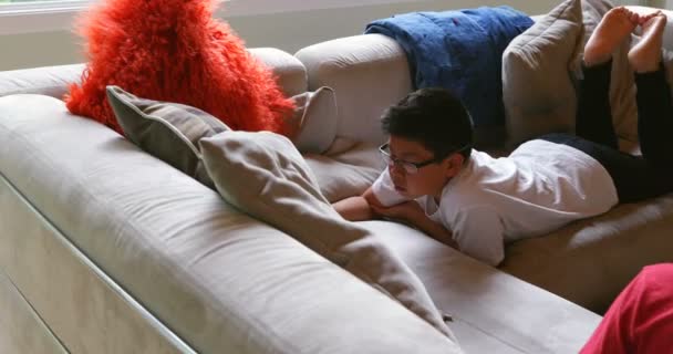 男孩在家使用数字式平板电脑在客厅4K — 图库视频影像
