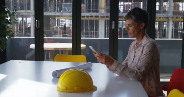 Vrouwelijke Ingenieur Met Behulp Van Mobiele Telefoon Balie Kantoor — Stockvideo