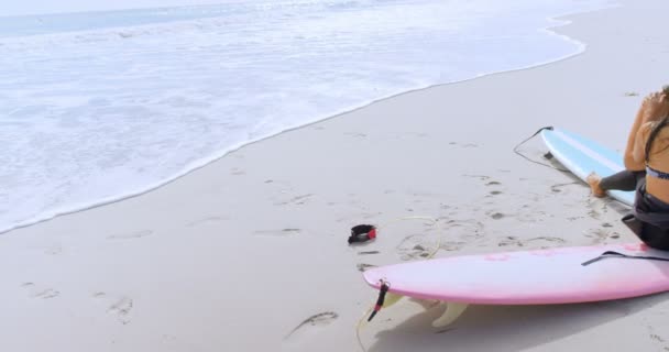 Surfer Par Sitter Surfbrädor Och Den Vilda Jakten Stranden — Stockvideo