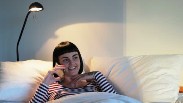 の自宅の寝室で携帯電話で話している女性 — ストック動画
