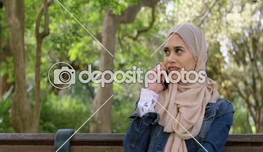 Cep telefonu 4 k bahçesinde konuşurken hijab kadında