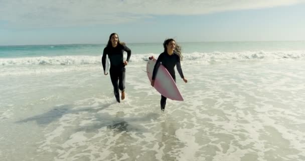 快乐的夫妇与冲浪板在海滩上运行4K — 图库视频影像