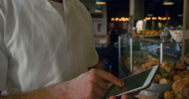 Männlicher Koch Hält Aufzeichnungen Auf Tablet Bäckereiladen — Stockvideo