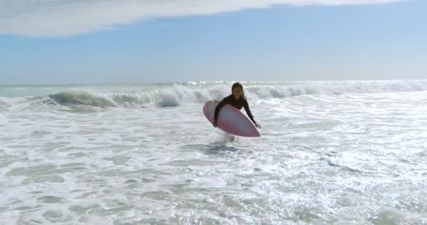 のビーチで海の上を実行しているサーフボードと女性 — ストック動画